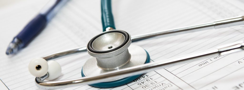 stethoscope and pen on top of a medical form