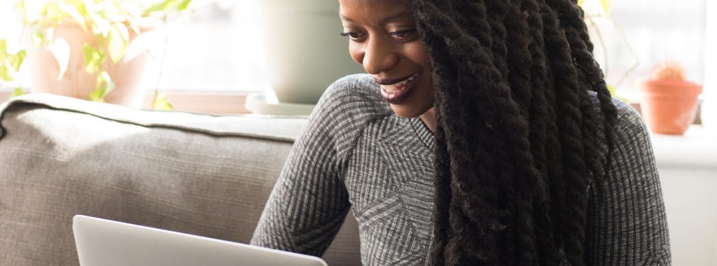 woman on couch using laptop
