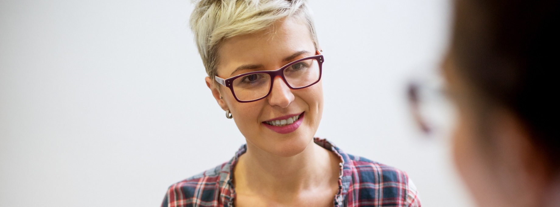 woman with short hair and red glasses